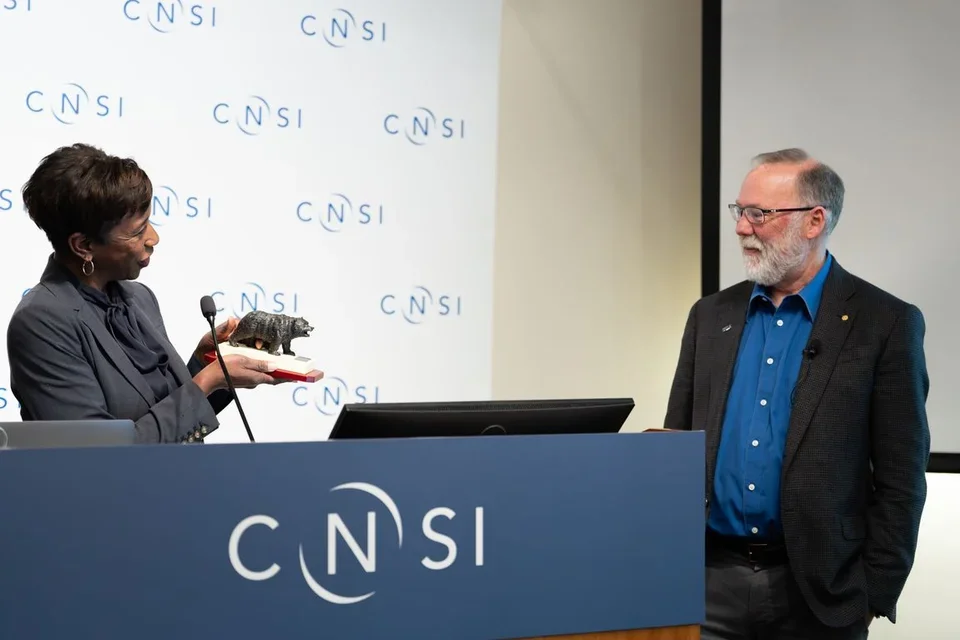 Dean Tracy Johnson presents Ramsdell with the Bruin Bear Award from the UCLA College’s department of microbiology, immunology and molecular genetics.