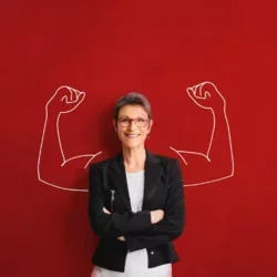 Women standing with painting of muscles in the background 