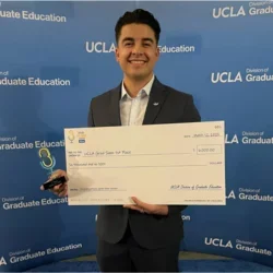 MIMG Graduate Student Pablo Alvarez smiling and holding 1st place winner check. 