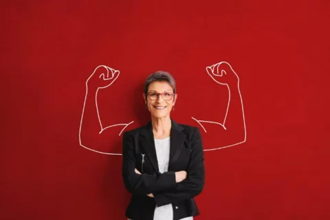 Women standing with painting of muscles in the background